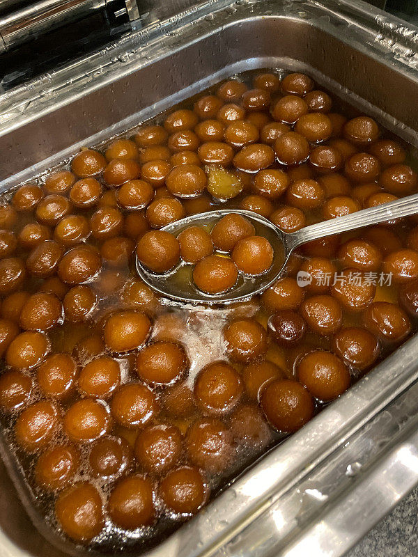 印度糖果店展示的Gulab jamun(玫瑰水浆果)Mithai(糖果)的餐饮托盘图像，浸泡在糖浆(水，糖豆蔻，玫瑰水和藏红花)中，高架视图，关注前景